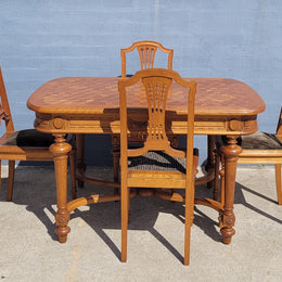 Beautiful carved French Oak dining table with a parquetry top and six matching upholstered chairs. All in good original detailed condition.