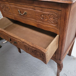 French Oak Louis XV style three drawer commode. It has been sourced from France and has decorative handles and carvings. It is in good original detailed condition.