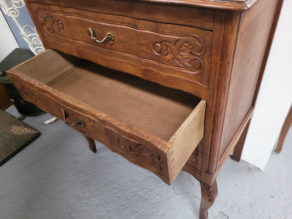 French Oak Louis XV style three drawer commode. It has been sourced from France and has decorative handles and carvings. It is in good original detailed condition.