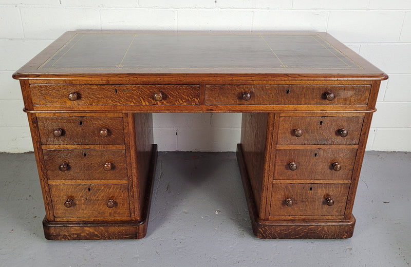 English Oak double pedestal desk with a tooled leather top . It has eight drawers in total and is in good original condition.