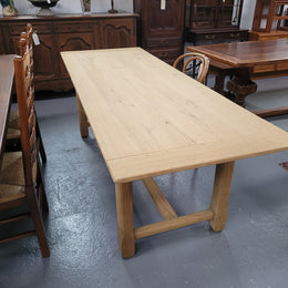 French raw Oak stretcher based refectory table. Features raw wood that could be used as is for a distressed look, or finished and waxed for a more refined look. Sourced from France and in good original condition.