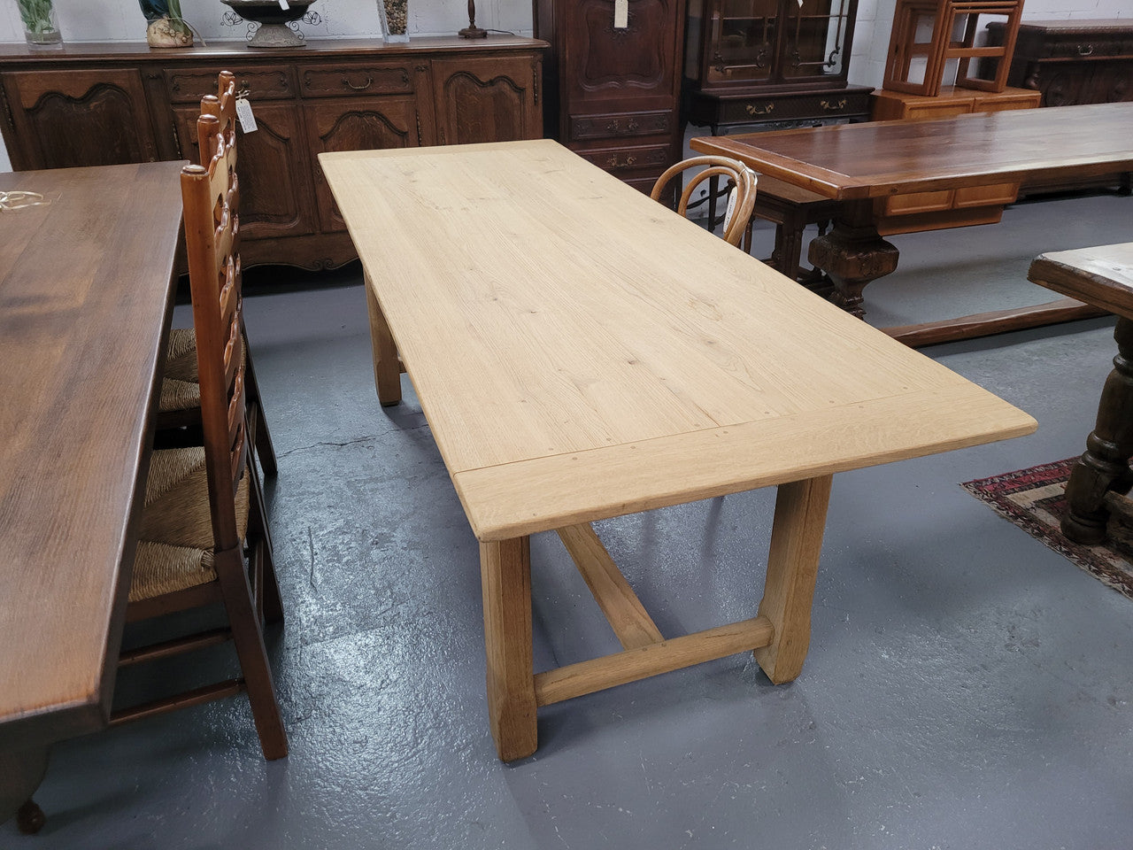 French raw Oak stretcher based refectory table. Features raw wood that could be used as is for a distressed look, or finished and waxed for a more refined look. Sourced from France and in good original condition.