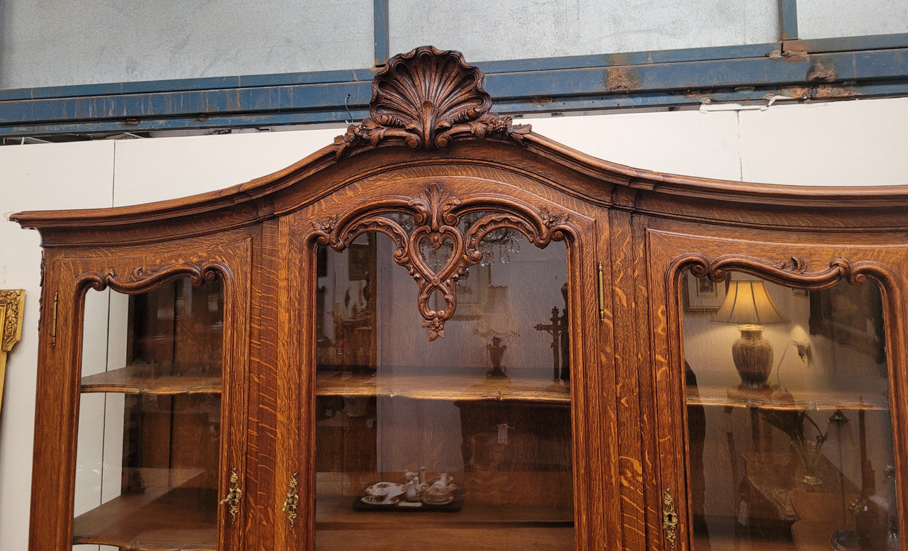Impressive French Oak Louis 14th Style Display and Sideboard. It has 4 drawers, 2 bottom cupboards with 6 total shelves and 3 display doors with 3 shelves.  In good, detailed condition.