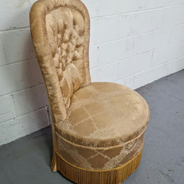 Vintage round upholstered button back bedroom chair. Beautiful gold upholstery in original condition with a gold fringe.
