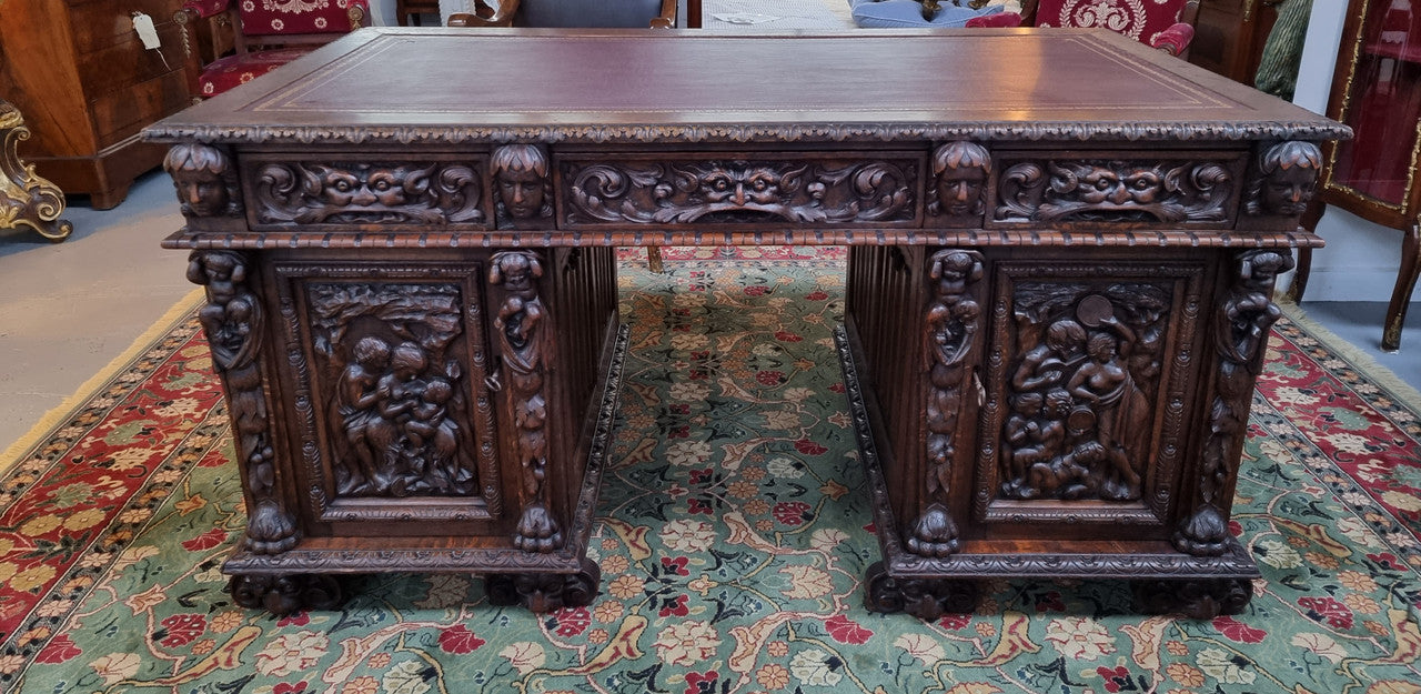 Beautifully carved French Oak early 19th century pedestal desk with 3 drawers, two cupboards and a secret cupboard on the side. There is also a lovely burgundy tooled leather top. In good original detailed condition.