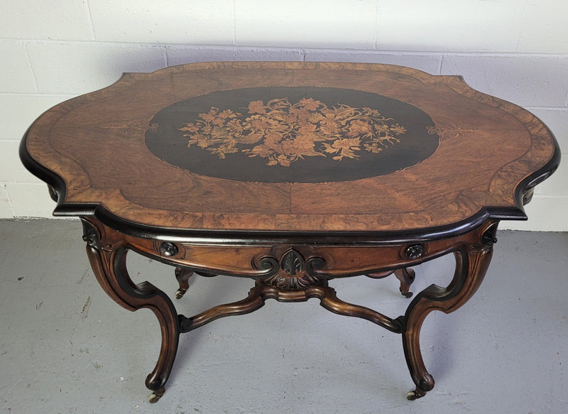 French Napoleon III style center table. Made from Rosewood and figured Walnut and is beautifully inlaid with an ebonized edge.  It has an attractive carved undercarriage and single drawer. In good original detailed condition.