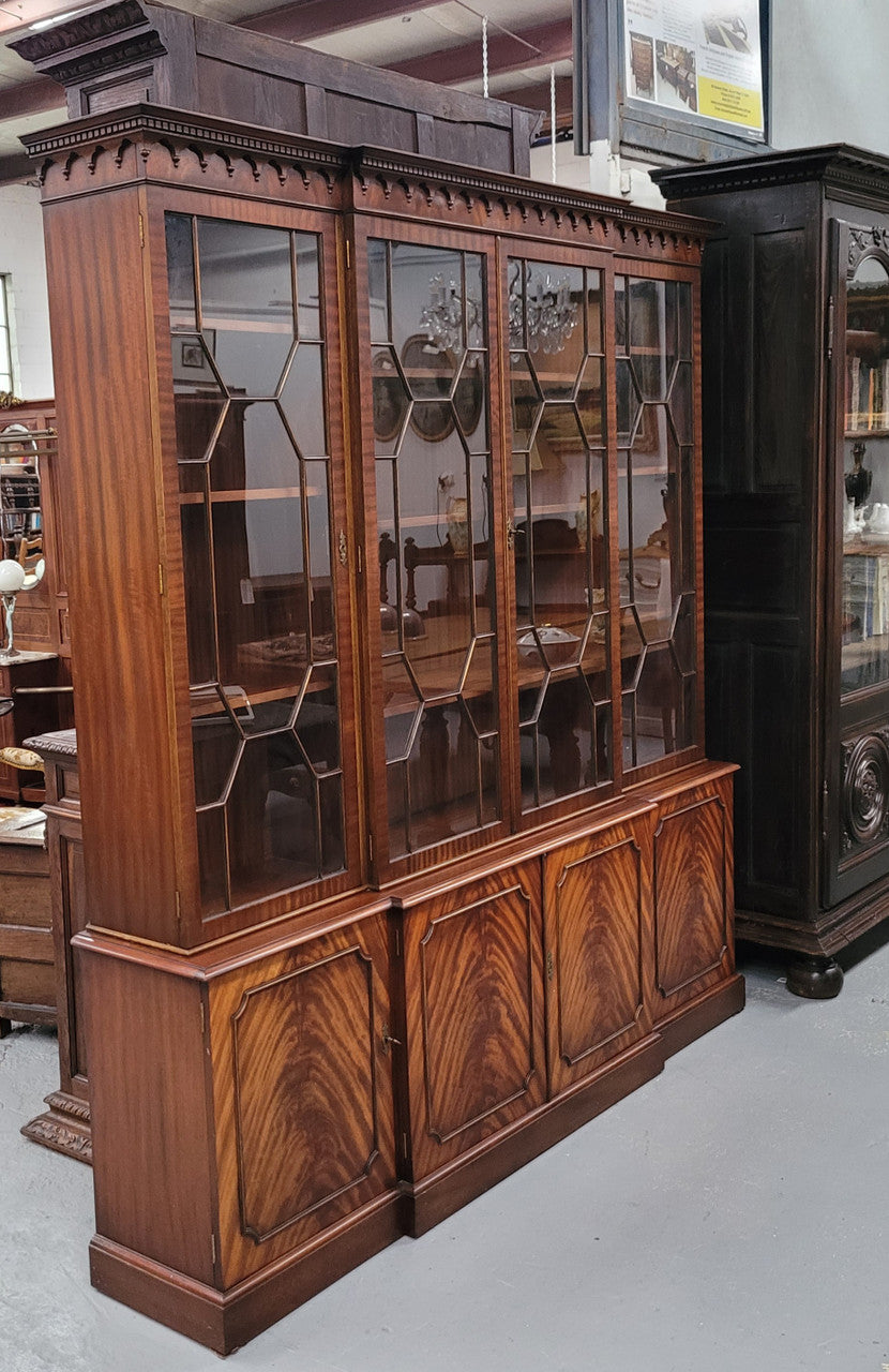 Georgian style Breakfront Flame Mahogany four door bookcase. A very impressive piece with plenty of storage and is of pleasing narrow proportions. It has been sourced locally and is in good original detailed condition.