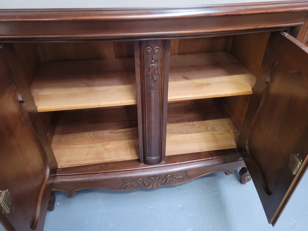 Fabulous Louis XV style French Walnut and Burr Walnut four door sideboard. Each door panel has beautiful Burr Walnut panels and open up to an adjustable shelf. Beautiful handles and two drawers for added storage. In good original detailed condition.