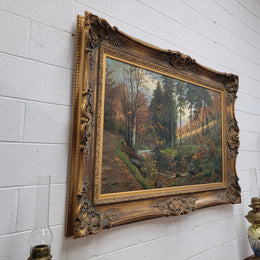 Large signed oil on canvas depicting a river stream in autumn framed in a stunning gilt frame. Sourced from France and is in good original detailed condition.