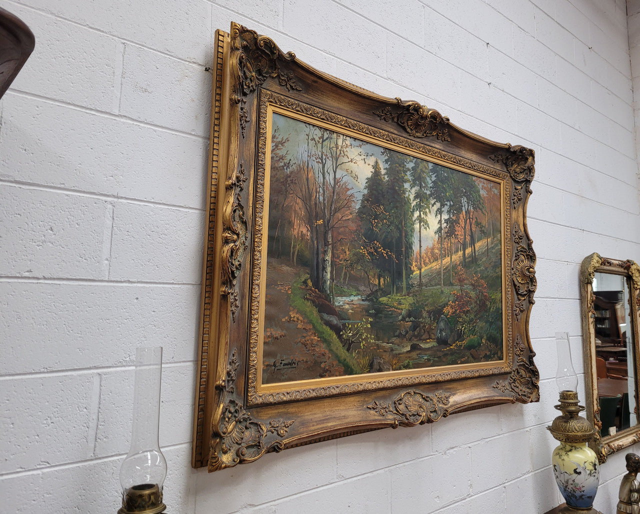 Large signed oil on canvas depicting a river stream in autumn framed in a stunning gilt frame. Sourced from France and is in good original detailed condition.