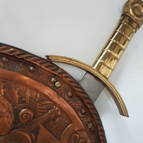 A beautiful European Antique highly detailed embossed copper shield with swords. Look closely to see the amazing detail in the shield of a fighting scene. It has brass handles on the steel swords. Is in good original condition with a slight crack (see photo).