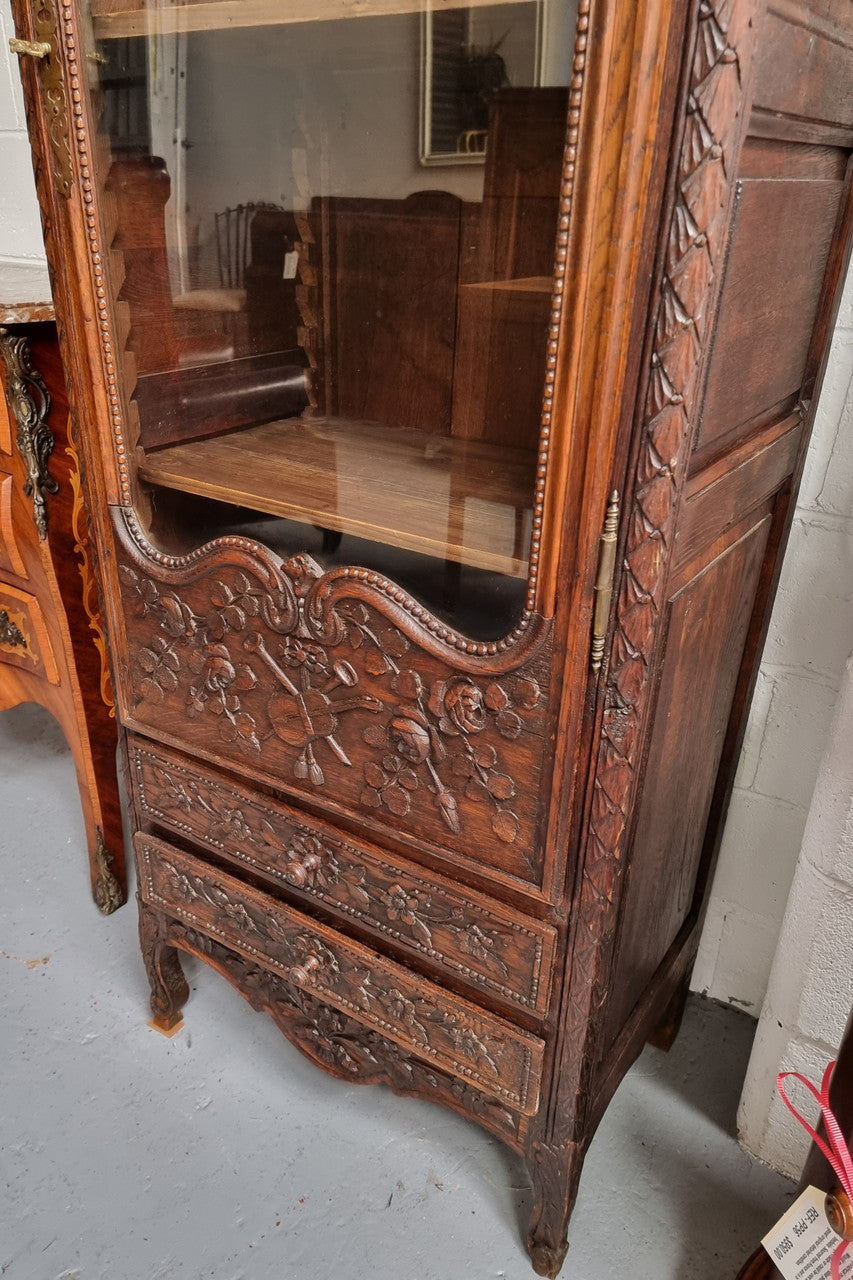 Petite oak armoire display cabinet with a glass door, two drawers at the bottom and three shelves inside. Late 18th Century and amazing detailed decorative carvings. Sourced from France and in good original condition.